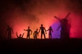 Silhouettes crowd of hungry zombies and old windmill on hill against dark foggy toned sky. Silhouettes of scary zombies walking at Royalty Free Stock Photo