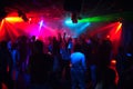 Silhouettes of a crowd of people dancing in a nightclub on the dance floor at a party