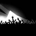 Silhouettes of a crowd with raised hands create a dynamic scene against a high