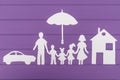 The silhouettes cut out of paper of man and woman with two girls and boy under the umbrella, house and car near Royalty Free Stock Photo