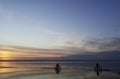 Silhouettes of cyclists at sunset of the day on the sandy bank of the river. Royalty Free Stock Photo