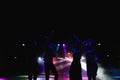 Silhouettes of dancing people in club in front of bright stage lights - disco concept. Royalty Free Stock Photo