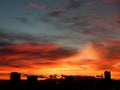 Silhouettes of distant buildings during crimson sunrise