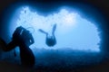 Silhouettes of divers at the exit of the underwater cave towards the sun Royalty Free Stock Photo
