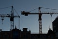 Silhouettes of elevating cranes Royalty Free Stock Photo