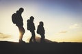 Silhouettes of father and two kids hiking at sunset Royalty Free Stock Photo