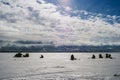 Silhouettes of fishermen fishing and snowmobile in winter on the ice Royalty Free Stock Photo