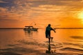 Silhouettes of the fishermen throwing fishing net during sunset in Dammam seaside Saudi Arabia Royalty Free Stock Photo