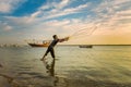 Silhouettes of the fishermen throwing fishing net during sunset in Dammam seaside Saudi Arabia Royalty Free Stock Photo