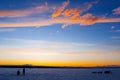 Silhouettes of fishermen on winter fishing on the ice of the river Royalty Free Stock Photo