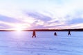 silhouettes of fishermen on a winter lake at sunset fishing. Winter landscape, winter sports Royalty Free Stock Photo