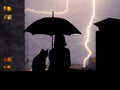 Silhouettes girl and cat under umbrella sitting on the roof high