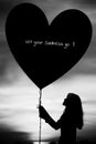 Silhouettes of a girl holding heart of sadness balloon Royalty Free Stock Photo