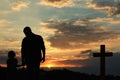 Silhouettes of godparent with child in field at sunset