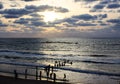 Silhouettes of a group of ipeople against the evening sea and sky