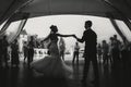 Silhouettes of happy bride and groom gently dancing at wedding reception. Gorgeous wedding couple of newlyweds embracing while Royalty Free Stock Photo