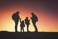 Silhouettes of happy family with two kids hiking at sunset Royalty Free Stock Photo