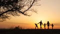 Silhouettes of happy family walking together in the meadow during sunset Royalty Free Stock Photo