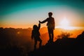 Silhouettes of happy little boy and girl hiking at sunset mountains Royalty Free Stock Photo