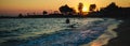 Silhouettes of happy people swimming and playing in the sea at sunset, concept about having fun on the beach Royalty Free Stock Photo