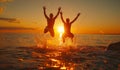 Silhouettes of happy young people jumping in sea at the sunset Royalty Free Stock Photo