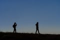 Silhouettes of hikers with backpacks enjoying sunset view from top of a mountain Royalty Free Stock Photo