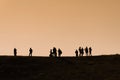 Silhouettes of hikers with backpacks enjoying sunset view from top of a mountain Royalty Free Stock Photo