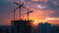 Silhouettes of houses under construction and tower cranes over amazing sunset sky Royalty Free Stock Photo