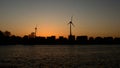 Silhouettes of houses, windmills and trees in last evening light