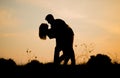 Silhouettes of hugging couple against the sunset sky. Vintage mood.