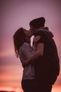 Silhouettes of hugging couple against the sunset sky. Vintage photo.