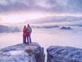 Silhouettes of hugging man and woman on mountain peak