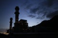 Silhouettes of industrial tower at dusk.