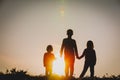 Silhouettes of kids - boy and girls - holding hands at sunset