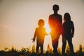 Silhouettes of kids - boy and girls - holding hands at sunset Royalty Free Stock Photo