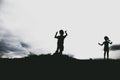 Silhouettes of kids jumping from a sand cliff at the beach Royalty Free Stock Photo