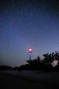 Silhouettes of the Lighthouse sandy beach and ocean against the background of the starry sky