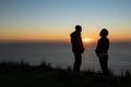 Silhouettes of lovers at sunset sky background