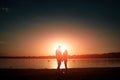 Silhouettes of a loving couple, beautiful sunset on a lake