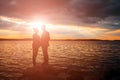 Silhouettes of a loving couple, beautiful sunset on a lake