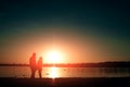 Silhouettes of a loving couple, beautiful sunset on a lake