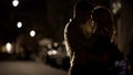 Silhouettes of loving couple embracing each other in the street, relationship