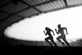 Silhouettes of Male and Female Runners Showcase Dedication and Synergy, Transcending Limits at a Modern Sports Stadium. Black and