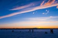 Silhouettes of male fishermen on winter fishing on the ice of the river Royalty Free Stock Photo