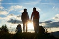 Silhouettes of man and woman looking at each other, holding hands against sunset in mountains Royalty Free Stock Photo