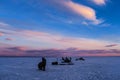 Silhouettes of men fishermen and snowmobiles on winter fishing Royalty Free Stock Photo