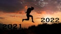Silhouettes of men jumping with joy and freedom on text number 2021 and 2022. Happy New Year concept. Royalty Free Stock Photo
