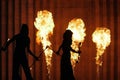 Silhouettes of men and women in the background of a stone wall and burning torches Royalty Free Stock Photo