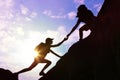 Silhouettes of man and woman helping each other to climb on hill Royalty Free Stock Photo