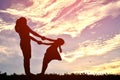 Silhouettes mother and daughter playing and hugging